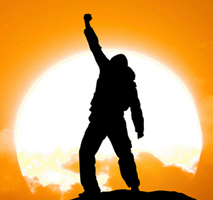 Person with fist in air at sunset